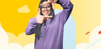 Girl facing the camera and using her fingers to create a square shape to mimic the camera framework.