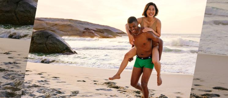 Man carries woman on his back on beach