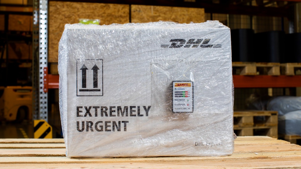 DHL extremely urgent parcel on a table in a warehouse. 